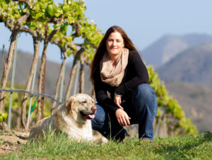 owner of Rancho Sisquoc Winery with dog in vineyard